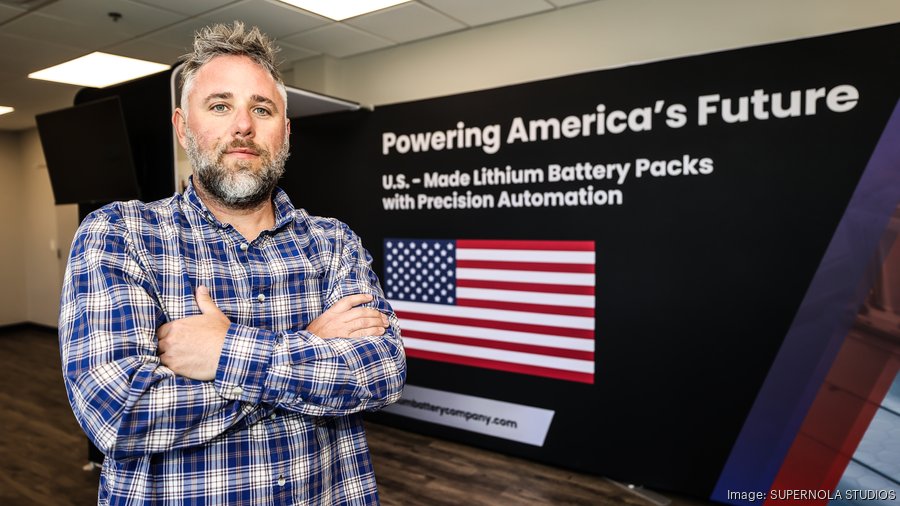 Nathan Staron, Reshore.AI founder, standing in front of a U.S.-made lithium battery-pack display