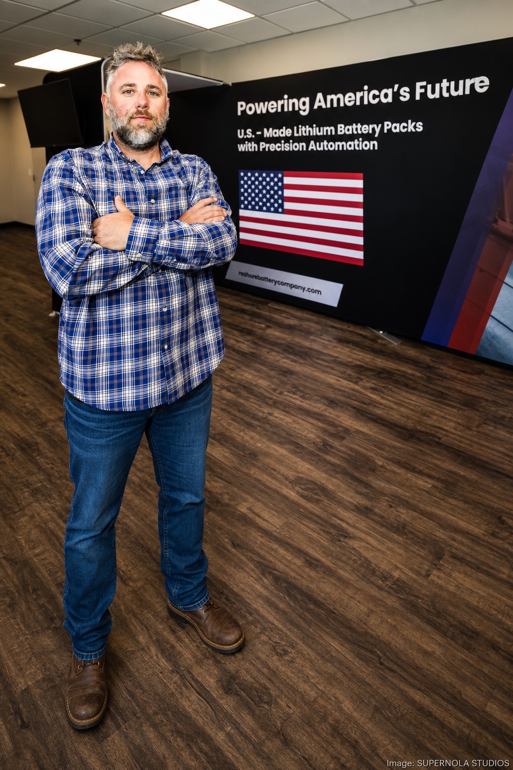 Nathan Staron, Reshore.AI founder, standing in front of a U.S.-made lithium battery-pack display